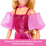 Barbie Deluxe Style #5 dukke i et metallisk pink blondt outfit med en glitrende overdel og glitrende bukser, med tilbehør inklusive en pink halskæde og en håndtaske, JFP40